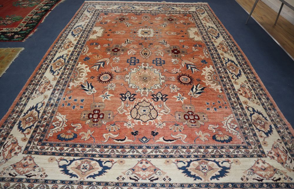 A large Persian pink ground carpet, woven with medallions and stylised flowers and leaves, approx. 410 x 290cm